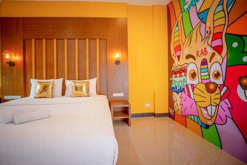 a room with two beds and a painting of a giraffe at Smart Hotel in Lam Luk Ka