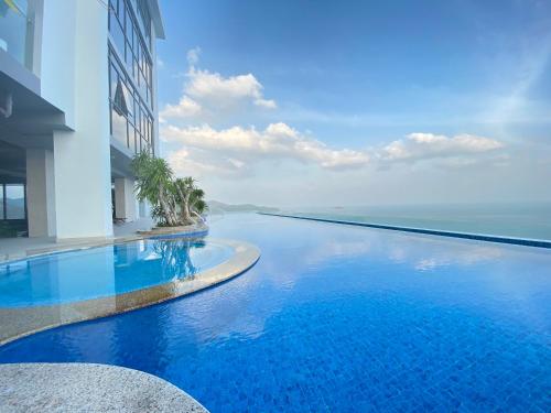 a large swimming pool next to a building with the ocean at Wise Stay Scenia Bay Apartment in Nha Trang