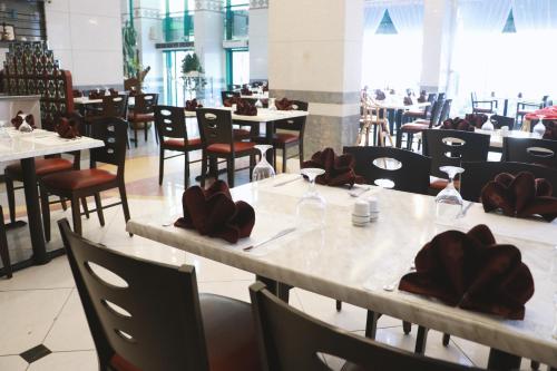 a dining room with tables and chairs and tablesktop at Spark Residence Hotel in Sharjah