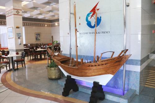 a wooden boat on display in a restaurant at Spark Residence Hotel in Sharjah