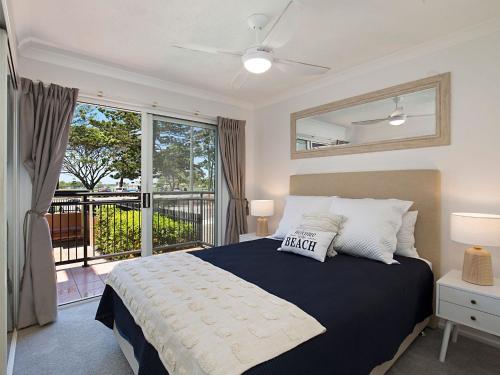 um quarto com uma cama grande e uma varanda em Peurto Vallerta Unit 2 em Gold Coast