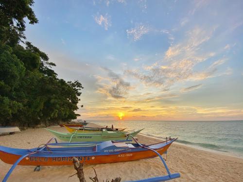 three boats parked on the beach at sunset at Jony's Beach Resort in Boracay