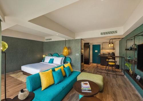 a living room with a bed and a blue couch at MAMAKA by Ovolo in Kuta