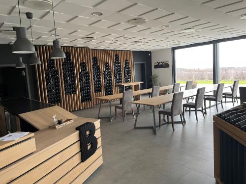 a dining room with tables and chairs and windows at Weingut Bugner Meizelhof in Klein-Winternheim