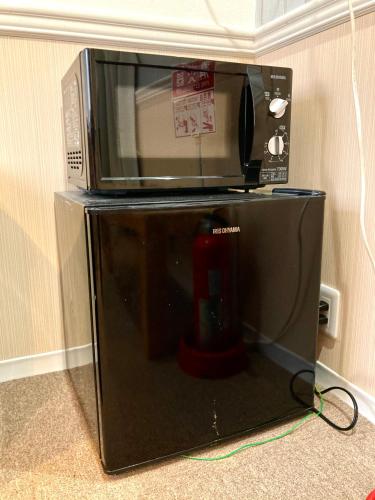 東京にあるbnb+ Shinbashiの冷蔵庫の上に置かれた電子レンジ