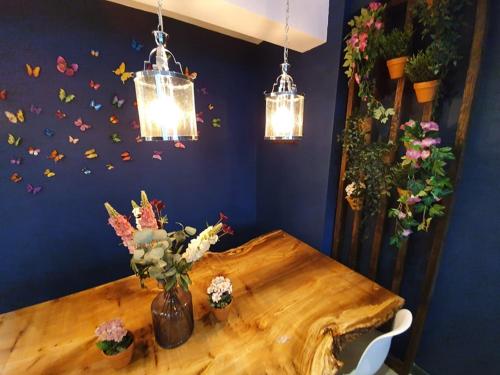 a wooden table with a vase of flowers and lights at Enchanted Hideaway, Bath in Bath