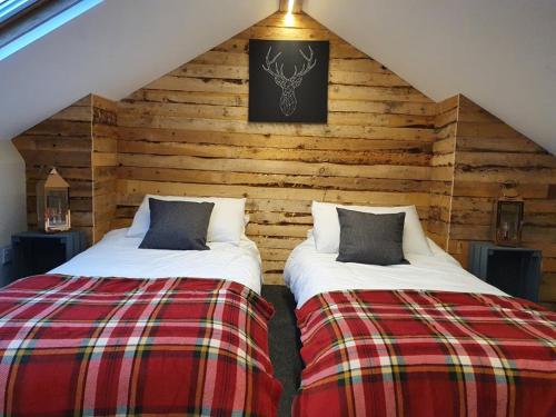 two beds in a room with wooden walls at Enchanted Hideaway, Bath in Bath