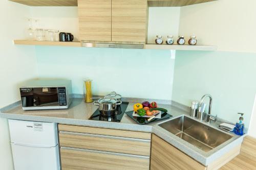 a kitchen with a sink and a bowl of fruit at Village Hotel Changi by Far East Hospitality in Singapore