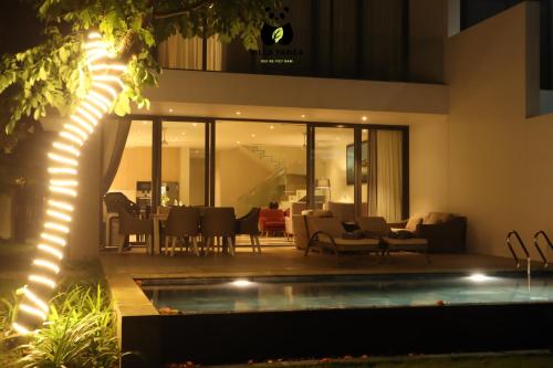 una casa con piscina por la noche en Villa Panda - Sanctuary Ho Tram Resort en Ho Tram