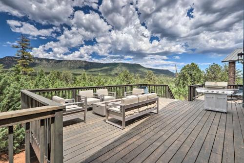a wooden deck with chairs and a table on it at Fire Pit, Deck and Mtn Views Upscale Pine Cabin! in Pine