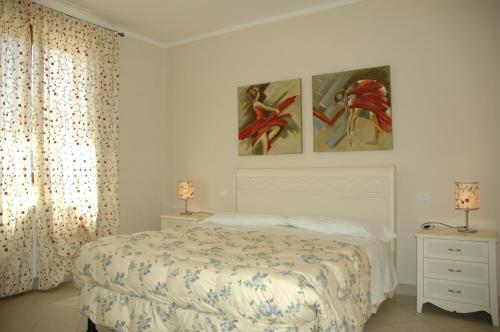 a bedroom with a bed and two paintings on the wall at Case Vacanza La Dolce Vita in Saturnia