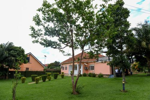 a house with a tree in the middle of a yard at Corinya Serviced Apartments in Entebbe