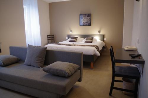 een slaapkamer met een bed en een bank en een bed bij Le Cadoudal in Auray