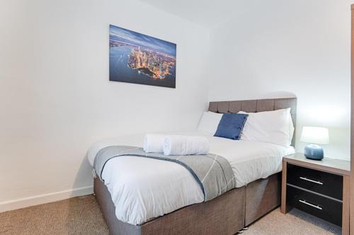 a bedroom with a large bed with a night stand at Perfect Base to Stay in Swansea - TV in every Bedroom! in Swansea