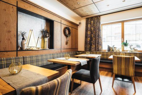 a restaurant with tables and chairs and a window at Hotel Garni Angela in Ischgl
