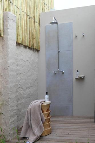 a bathroom with a shower with a towel on a table at Scallop Lodge in Plettenberg Bay
