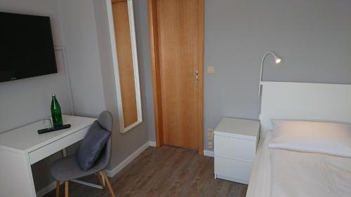 a bedroom with a desk and a bed and a chair at Ostseehotel Kappeln by team SchleiFee in Kappeln