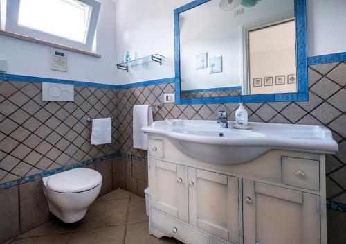 a bathroom with a sink and a toilet and a mirror at B&B Il Vicolo in Anacapri