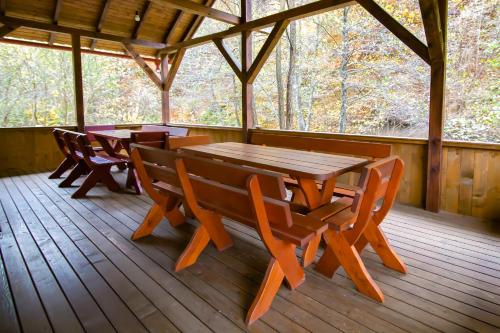 una mesa de madera y sillas en la cubierta de una cabaña en Patakmenti Panzió Spa, en Corund