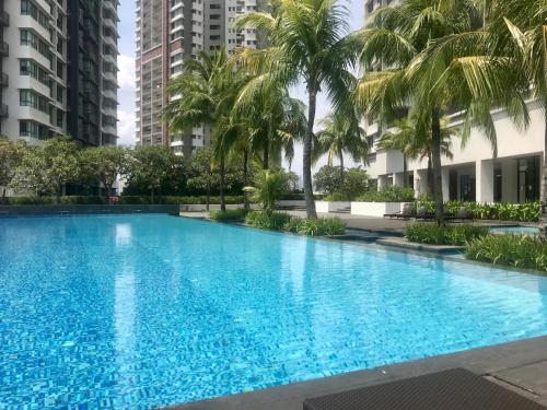 a large swimming pool with palm trees and buildings at KM1 West Kuala Lumpur, Malaysia in Kuala Lumpur