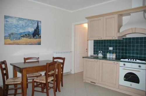 a kitchen with a table and a stove top oven at Case Vacanza La Dolce Vita in Saturnia