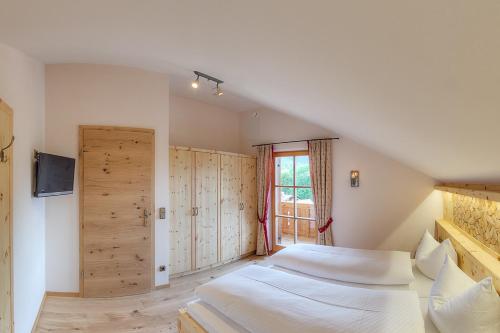 a bedroom with two beds and a sliding door at Ferienwohnungen im Rosengarten in Ruhpolding