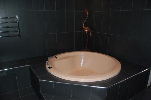 a bathtub with a light shining on it at Federation Motel Resort - Corowa in Corowa