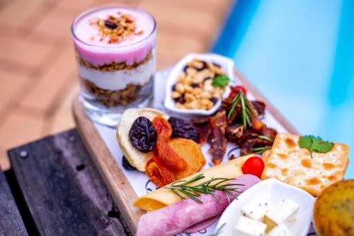 een dienblad met eten op een tafel met een drankje bij Presidents Boutique Lodge by Ilawu in Vryheid