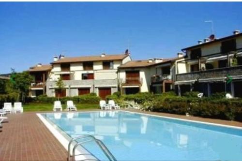 a large swimming pool in front of a building at Villa con ampio giardino esterno e piscina condominiale in Garda