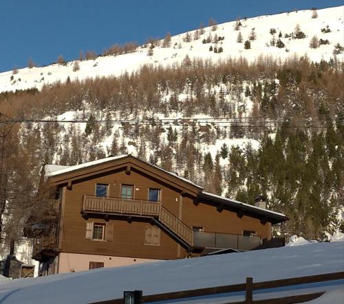 a building with a balcony in the snow at Al Dos in Livigno