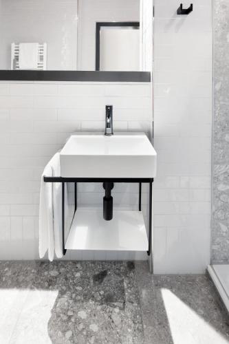 a bathroom with a white sink and a mirror at art Hotel Tucholsky in Bochum