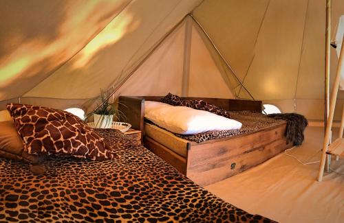 - une chambre avec 2 lits dans une tente dans l'établissement Slowly Glamping Osada Nad Wodą, à Łazy