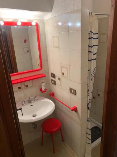 a bathroom with a sink and a red stool and a mirror at Hameau De Jadis in Pré-Saint-Didier