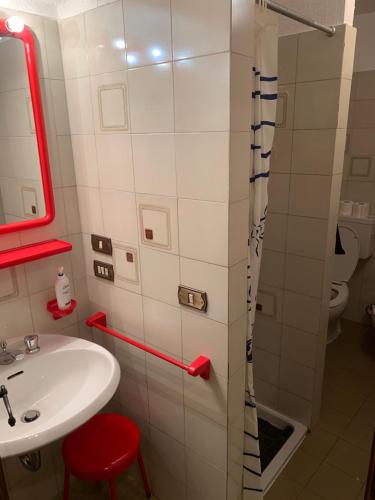 a bathroom with a sink and a shower with a red stool at Hameau De Jadis in Pré-Saint-Didier