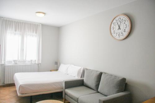 a room with a bed and a clock on the wall at APARTAMENTS COLELLS in Bordes d´Envalira