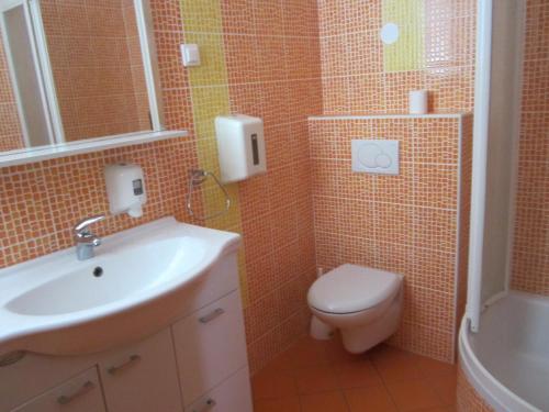 a bathroom with a white sink and a toilet at Guesthouse Punta Mira - Beachfront in Novalja