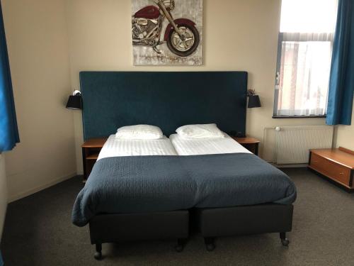 - une chambre avec un lit à tête bleue dans l'établissement Hotel Wilhelmina, à Venlo