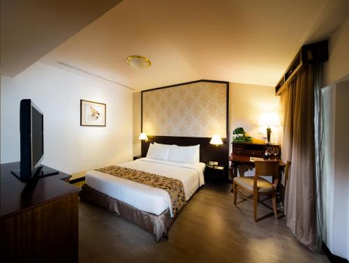 a hotel room with a bed and a desk at Village Hotel Albert Court by Far East Hospitality in Singapore
