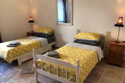 a bedroom with two beds and a mirror and lamps at Beautiful Eymet Bastide house & courtyard garden in Eymet