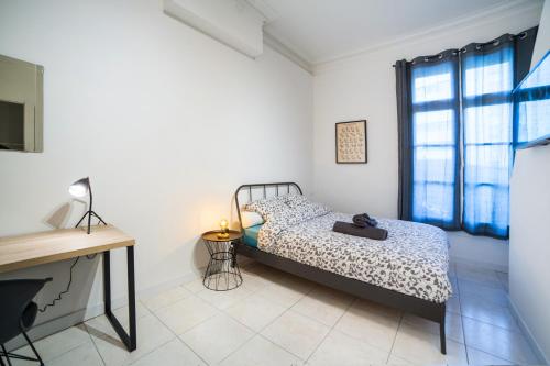 een slaapkamer met een bed, een bureau en een raam bij LGC Habitat- chambre privée- appartement commun- gare Saint-Roch in Montpellier