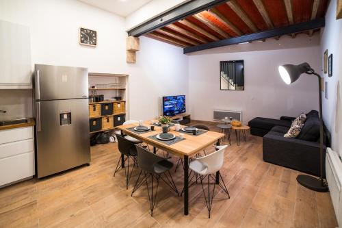 een keuken en een woonkamer met een tafel en een koelkast bij LGC Habitat- chambre privée- appartement commun- gare Saint-Roch in Montpellier