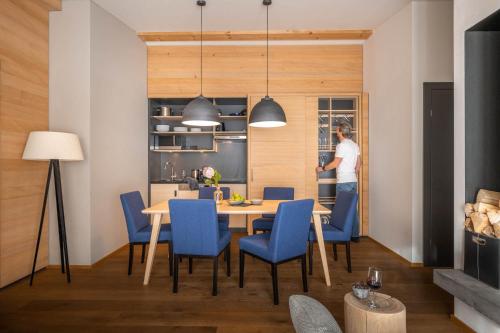 a dining room with a table and blue chairs at Sporthotel Chalet in Gaschurn