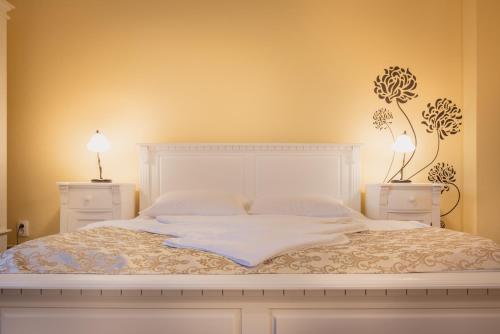 1 dormitorio con 1 cama blanca y 2 mesitas de noche en Casa Sasului, en Bazna