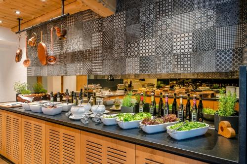 a buffet line with bowls of food and wine bottles at Hotel Der Bär in Ellmau