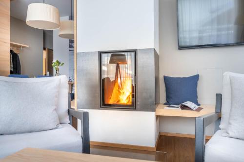 a living room with a fireplace in the wall at Sporthotel Chalet in Gaschurn