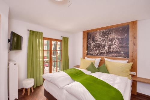 a bedroom with a green and white bed and a window at Ferienwohnungen Mayer inkl. Chiemgaukarte in Ruhpolding