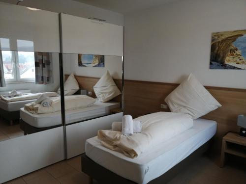 1 dormitorio con 2 camas y espejo en Hotel-Restaurant Zum Bäumle, en Süßen