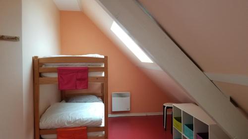 a attic room with bunk beds and a staircase at Gîte de montagne du Plateau de Lhers in Accous