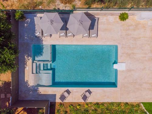 una vista aérea de una piscina con sillas y sombrillas en Estella Villa with Pool, Children Area, BBQ & Magnificent Views!, en Astérion