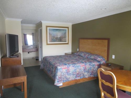 a hotel room with a bed and a table at National Inn Garden Grove in Anaheim